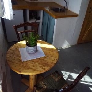 una mesa de madera con una maceta. en Venduri House en Péran Triovasálos