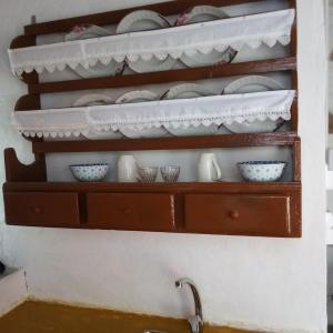 a shelf with plates and bowls on it at Venduri House in Péran Triovasálos