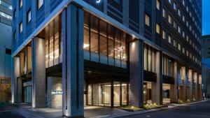 an office building with large windows at night at Via Inn Prime Nihonbashi Ningyocho in Tokyo