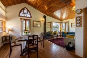 un salon avec une table, des chaises et un canapé dans l'établissement ama Stays & Trails Ballyhack Cottage,Shimla, à Shimla
