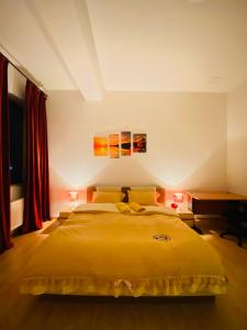 - une chambre avec un grand lit jaune et un bureau dans l'établissement Gobi-Girl, à Oulan-Bator