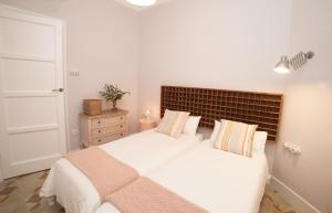 um quarto branco com uma grande cama branca com almofadas em La Casa de Santa Florentina-Parking incluido - 100 m2 em Cartagena