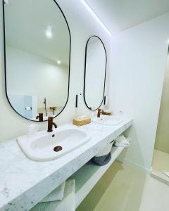 a bathroom with two sinks and a mirror at Hotel Bell-X Kortrijk-Wevelgem in Wevelgem