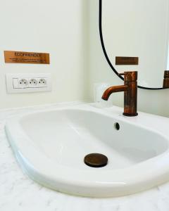 a white sink sitting under a mirror in a bathroom at Hotel Bell-X Kortrijk-Wevelgem in Wevelgem