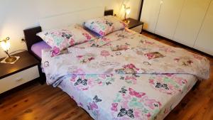 a bedroom with a bed with a comforter with butterflies at Apartmani Marija in Baška