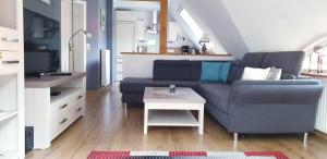 een woonkamer met een blauwe bank en een tafel bij Ferienwohnung Anna in Marienhafe