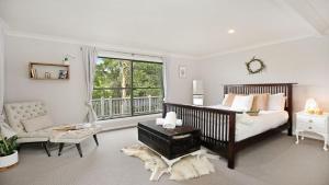 a bedroom with a bed and a chair and a window at Tree Scape Retreat in Robertson