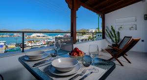 a dining table with a view of a marina at apagio project by almelon houses in Elounda