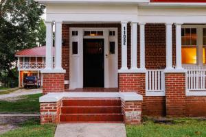 a red brick house with a black door at Stegall Manor Estates in Tuskegee