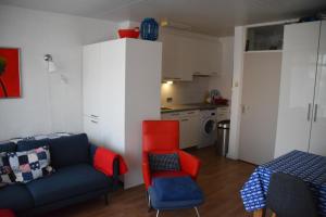 een woonkamer met een blauwe bank en een rode stoel bij Duinstraatje 3 in Zoutelande