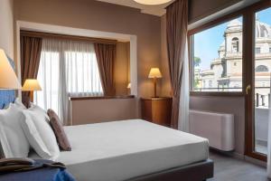 ローマにあるBeYou Hotel Ponte Milvioのベッドと大きな窓が備わるホテルルームです。