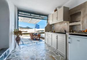 une cuisine avec des placards blancs et une vue sur l'océan. dans l'établissement Sarakiniko Boat House, à Mandrakia