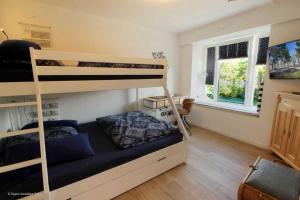 1 Schlafzimmer mit 2 Etagenbetten und einem Fenster in der Unterkunft FeWo Prora - Njoerd in Binz