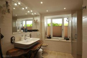 ein Bad mit einem Waschbecken und einem Spiegel in der Unterkunft FeWo Prora - Njoerd in Binz