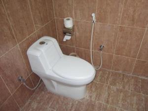 a bathroom with a white toilet in a room at Desert Retreat Camp in Al Wāşil