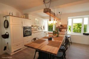 eine Küche mit einem Holztisch und eine Küche mit weißen Schränken in der Unterkunft FeWo Prora - Njoerd in Binz