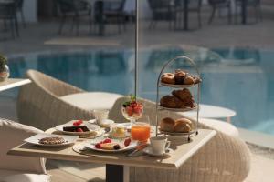 a tray of breakfast food on a table next to a pool at La Residenza Capri in Capri