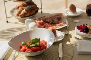 a table with a bowl of tomatoes and other foods at La Residenza Capri in Capri