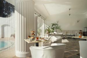a living room with a table and chairs and a pool at La Residenza Capri in Capri