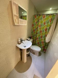 y baño con lavabo, aseo y ducha. en Room in Guest room - Central Area Bedroom With Common Kitchen, living room, en Sosúa