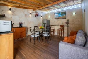 eine Küche und ein Wohnzimmer mit einem Tisch und Stühlen in der Unterkunft Room in Guest room - Central Area Bedroom With Common Kitchen, living room in Sosúa