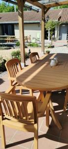 a wooden table and chairs on a patio at De Groene Hoeve in Brakel