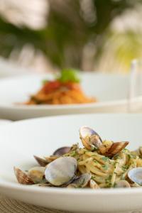 a plate of pasta with shrimp and clams on a table at La Residenza Capri in Capri