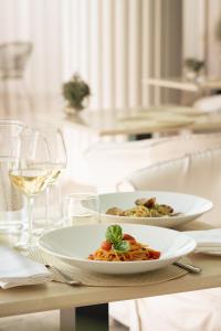 a plate of pasta on a table with wine glasses at La Residenza Capri in Capri