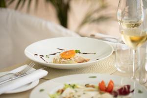 a table with two plates of food and a glass of wine at La Residenza Capri in Capri