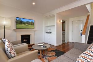 a living room with a couch and a fireplace at Villa 2br Grange Villa located within Cypress Lakes Resort in Pokolbin