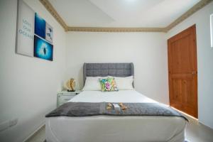 a bedroom with a large bed with two stuffed animals on it at Room in Guest room - Central 1bd and Bth with common Picuzzi in Sosúa