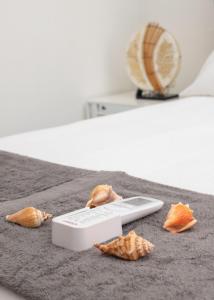 un mando a distancia sentado en una cama con algunas hojas en Room in Guest room - Central 1bd and Bth with common Picuzzi en Sosúa
