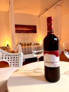 una bottiglia di vino seduta su un tavolo con un bicchiere di Agriturismo I Prati di Venere a Sesta Godano