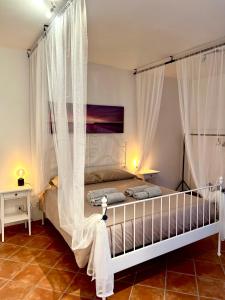 a bedroom with a bed with white curtains at Agriturismo I Prati di Venere in Sesta Godano