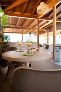 two glasses of wine sitting on a wooden table at Gu Hotel in Guidonia