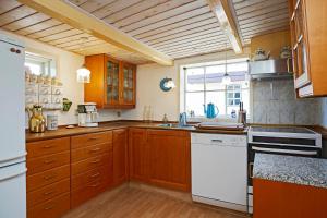 a kitchen with wooden cabinets and white appliances at Skrædderens Hus in Horsens
