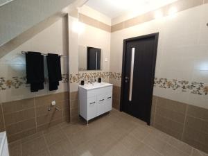 a bathroom with a sink and a black door at Moonlight Apartments Sibiu in Sibiu +26 photos