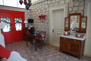 a bedroom with a red door and a desk with a computer at Mercan Köşk in Alacati