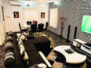 a living room with a couch and a tv at Harmony Homes Ibadan: Modern 3BR Duplex in Oluyole in Ibadan