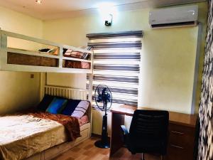 sypialnia z łóżkiem piętrowym i biurkiem z wentylatorem w obiekcie Harmony Homes Ibadan: Modern 3BR Duplex in Oluyole w mieście Ibadan