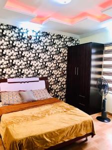a bedroom with a bed and a black and white wall at Harmony Homes Ibadan: Modern 3BR Duplex in Oluyole in Ibadan