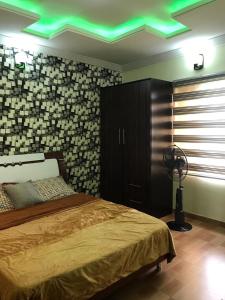 a bedroom with a bed and a green ceiling at Harmony Homes Ibadan: Modern 3BR Duplex in Oluyole in Ibadan