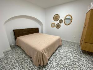 a bedroom with a bed and a mirror on the wall at Estudio da Moeda in Évora