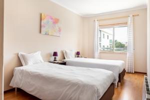 Postel nebo postele na pokoji v ubytování JOIVY Gorgeous 2-bed apt in Alcabideche parking