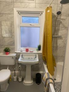 een badkamer met een wastafel, een raam en een toilet bij 1 bedroom spacious apartment in Lytham St Annes