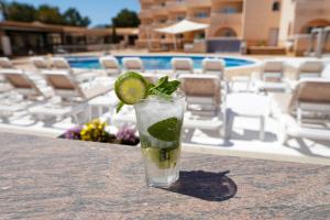 drinka na stole obok basenu w obiekcie Rosamar Ibiza Hotel w mieście San Antonio Bay