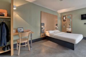 タルノスにあるB&B HOTEL Bayonne Tarnosのベッドルーム1室(ベッド1台、デスク、椅子付)