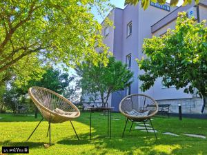 two chairs sitting in the grass in front of a building at La Pietra Family Hotel in Međugorje