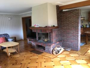 a living room with a brick fireplace and a table at Tammehouse in Otepää