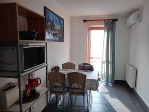 a kitchen with a table with chairs and a television at Borostyán Vendégház in Balatonkeresztúr